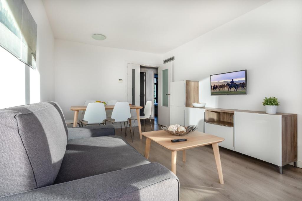un soggiorno con divano e tavolo di Agaró Cambrils Apartments a Cambrils