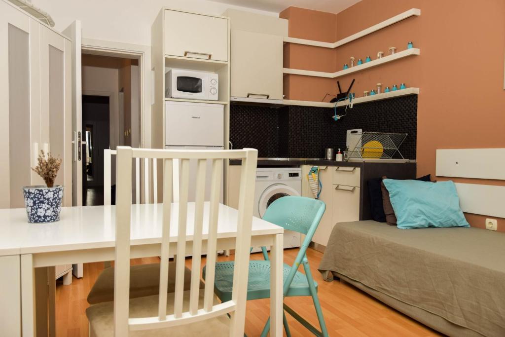 een keuken en een woonkamer met een tafel en stoelen bij Apartment Coral in Pomorie