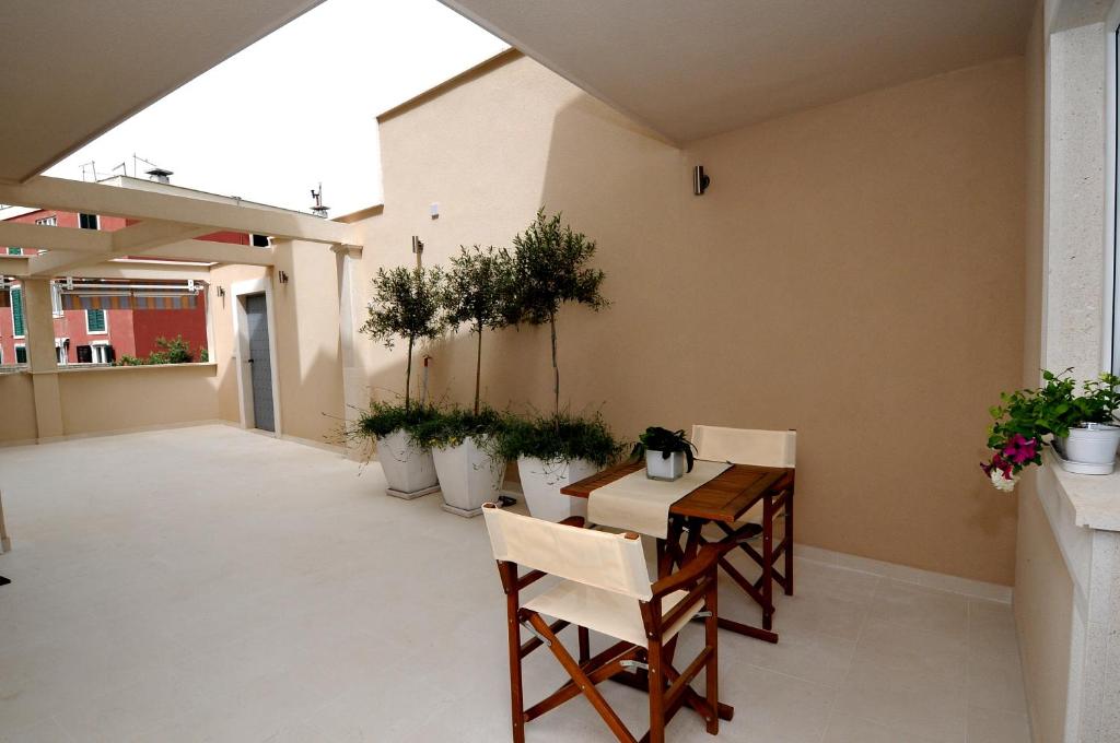 a patio with a table and chairs and potted plants at Apartments Annette - studio and two bedroom apartment with parking in Dubrovnik