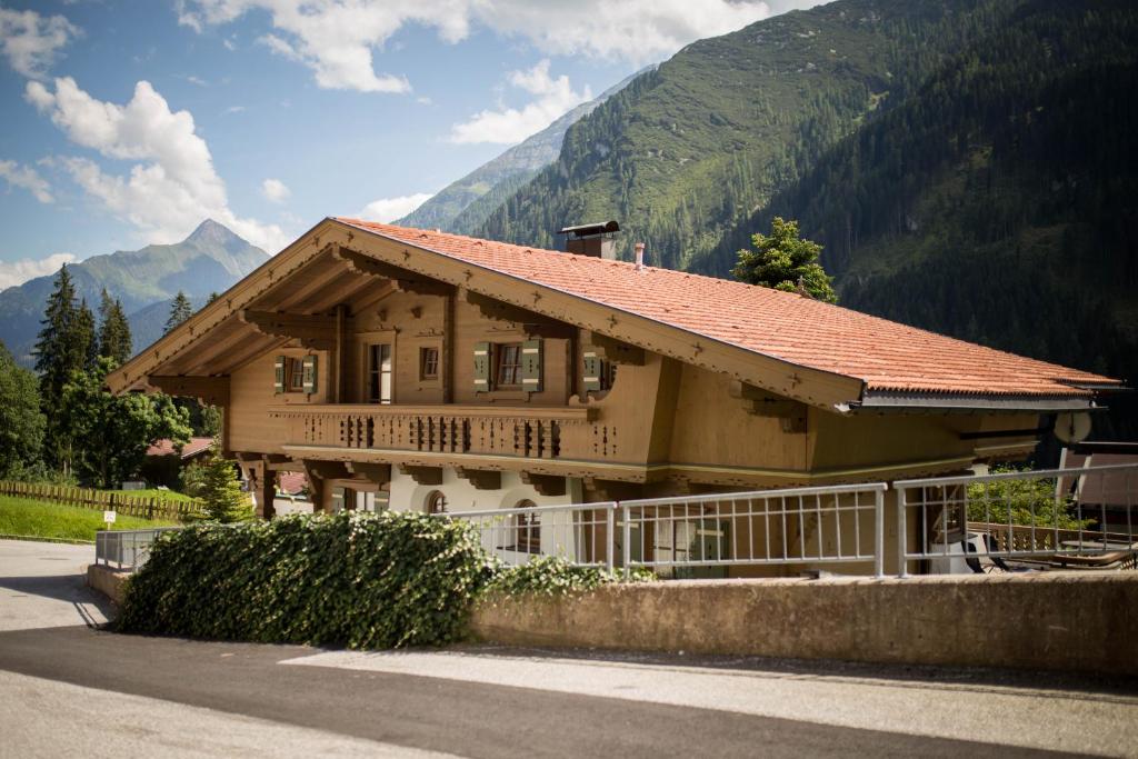 a house with a fence in front of a mountain at Landhaus Erlzette in Tux