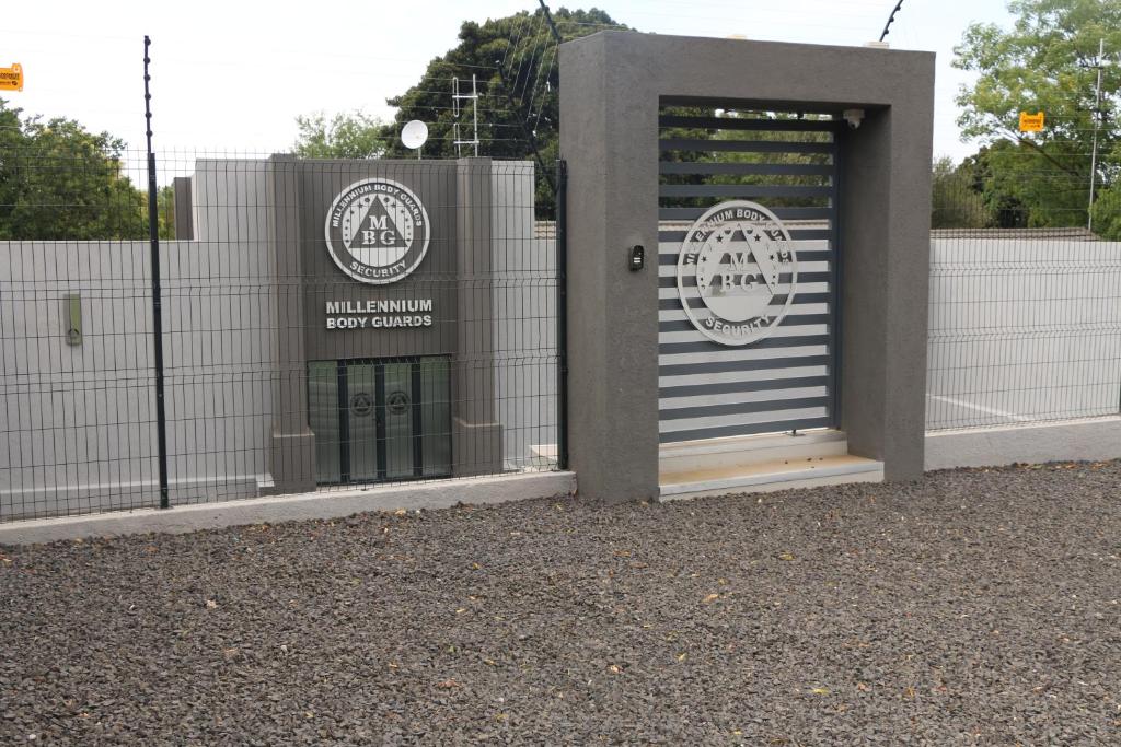 un edificio con una puerta con un cartel. en Millennium Body Guards Guesthouse en Hartbeespoort