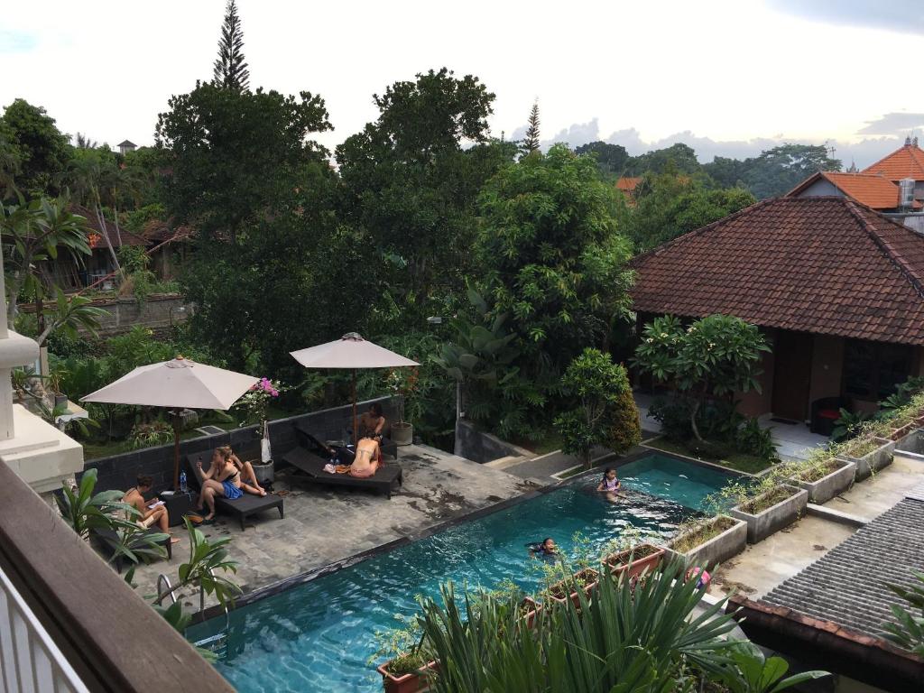 a group of people sitting in a swimming pool at Merthayasa Bungalow 2 in Ubud