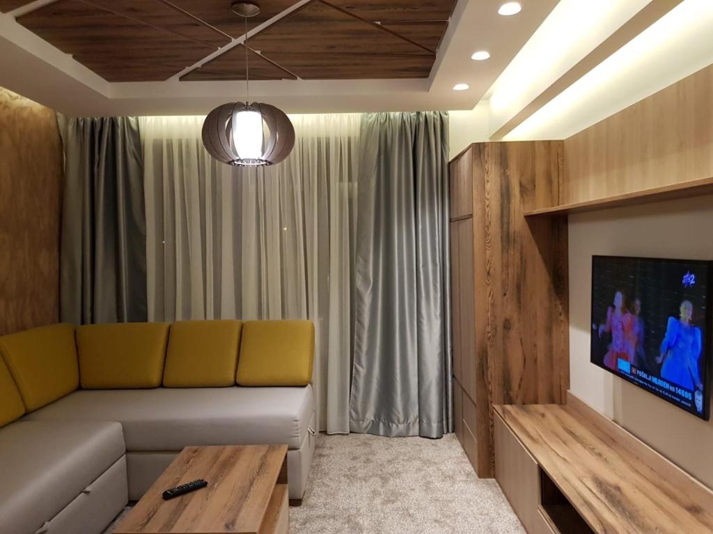 a living room with a couch and a tv at Apartmani Astoria 1 in Jahorina
