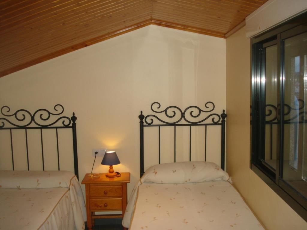 ポルトノボにあるATICO LAS FLORESのベッドルーム1室(ベッド2台、ナイトスタンドのランプ付)