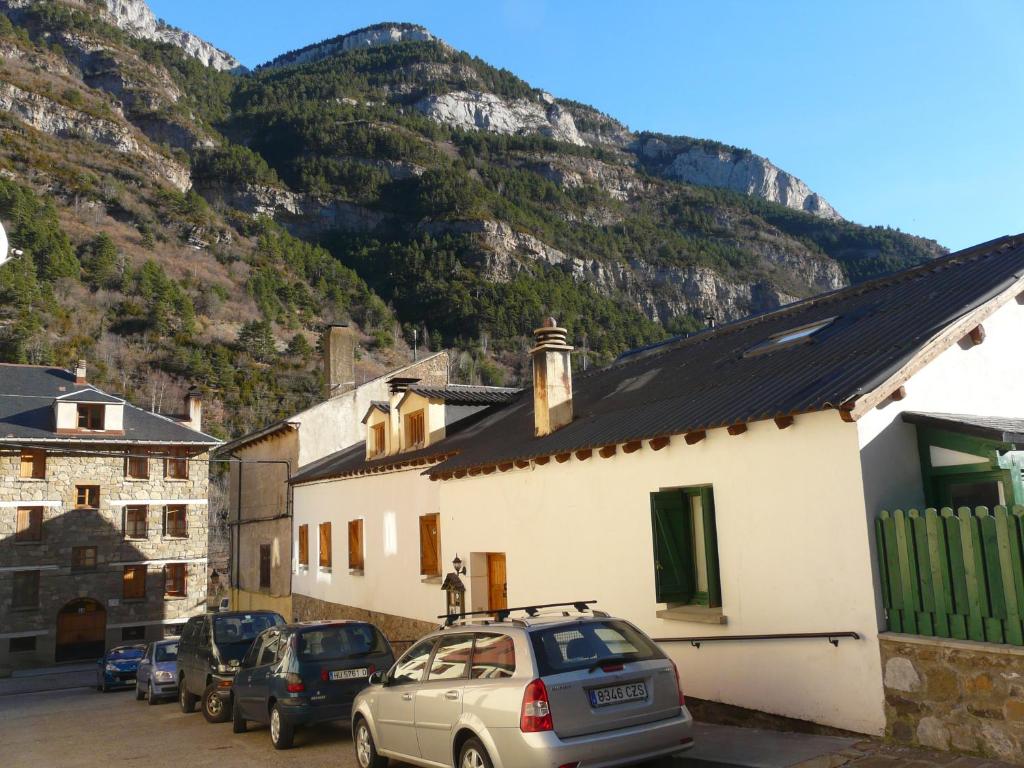 una pequeña ciudad con coches estacionados frente a una montaña en La Cabaña, en Canfranc