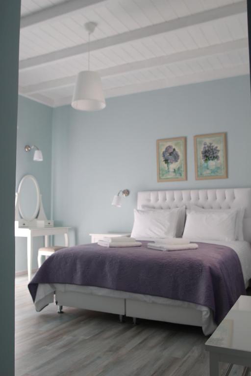 1 dormitorio con 1 cama grande con manta morada en Sugar Home, en Xylokastro