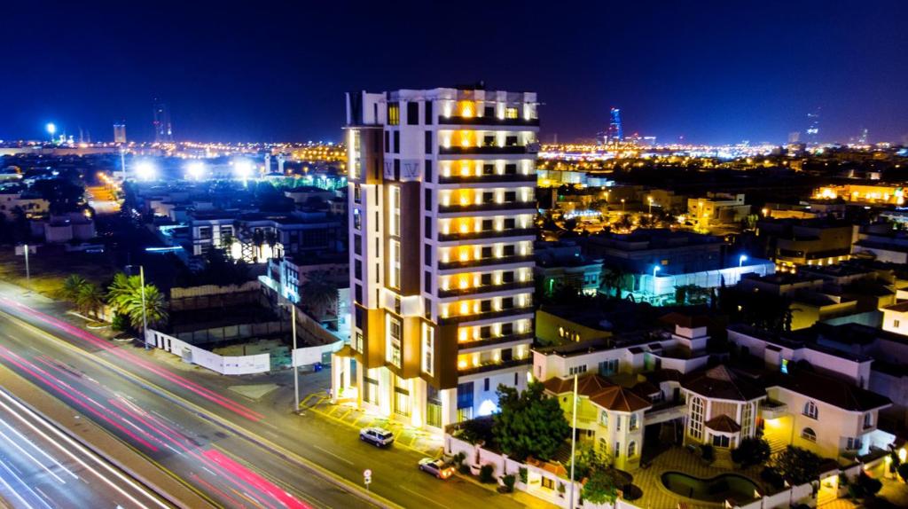 a city at night with a tall white building at V Boutique Hotel in Jeddah