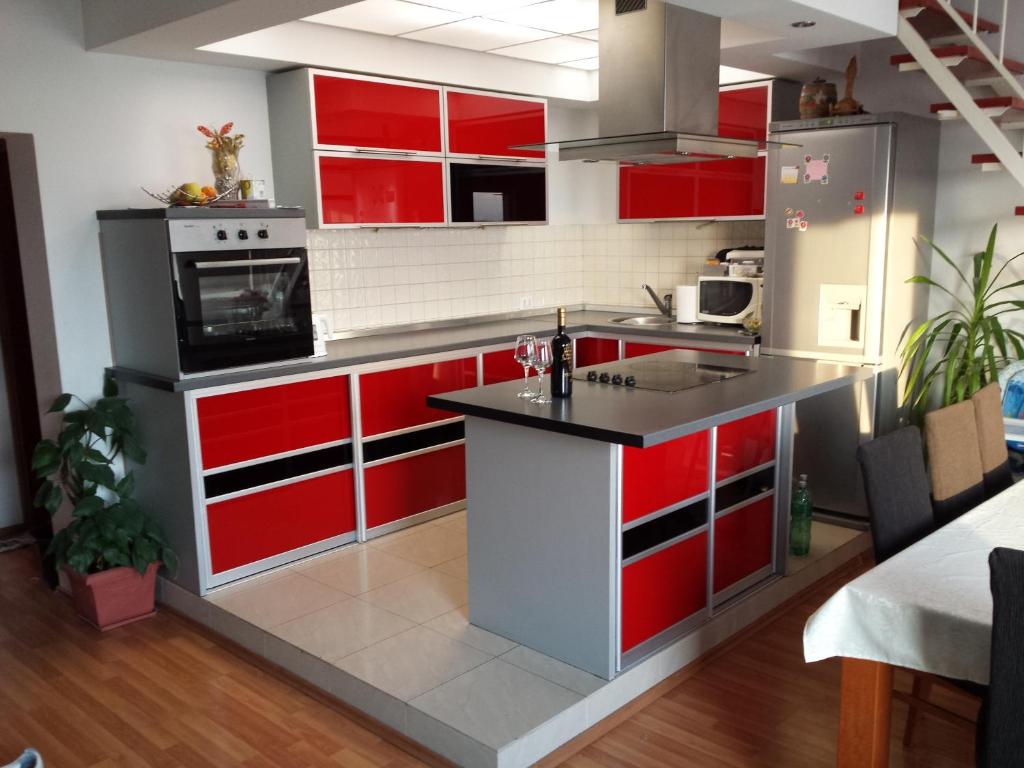 una cucina rossa e bianca con armadi rossi di Apartments Seven Castles a Kaštela (Castelli)