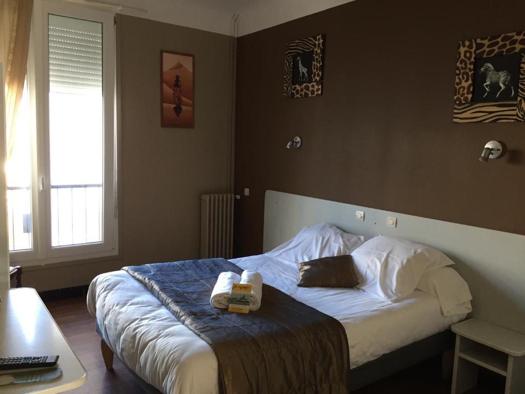 a bedroom with a bed with a book on it at Crystal Hotel in Royan