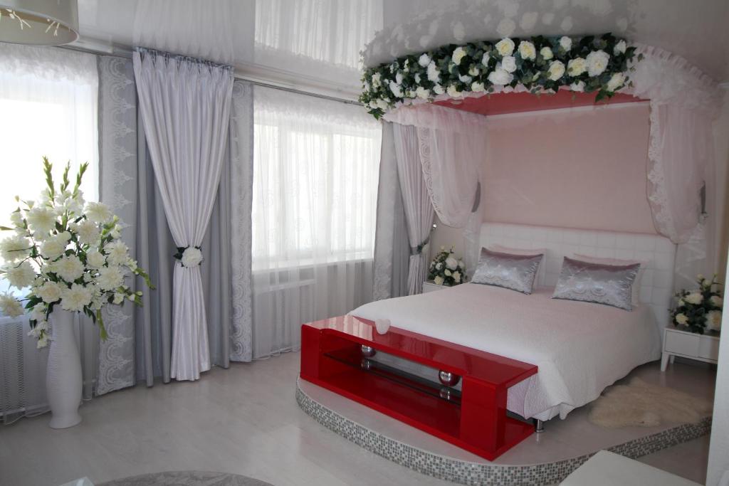a bedroom with a white bed with a red canopy at Hotel Buzuluk in Buzuluk