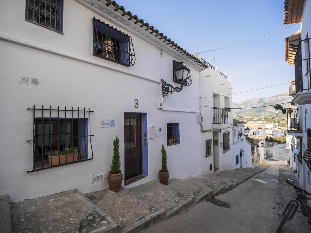 a narrow alley with white buildings and potted plants at Casa Carmen Altea with Terrace in Altea