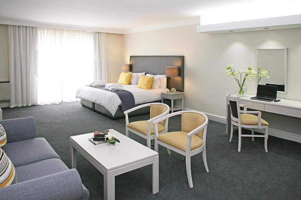 a hotel room with a bed and a living room at Hollow on the Square City Hotel in Cape Town