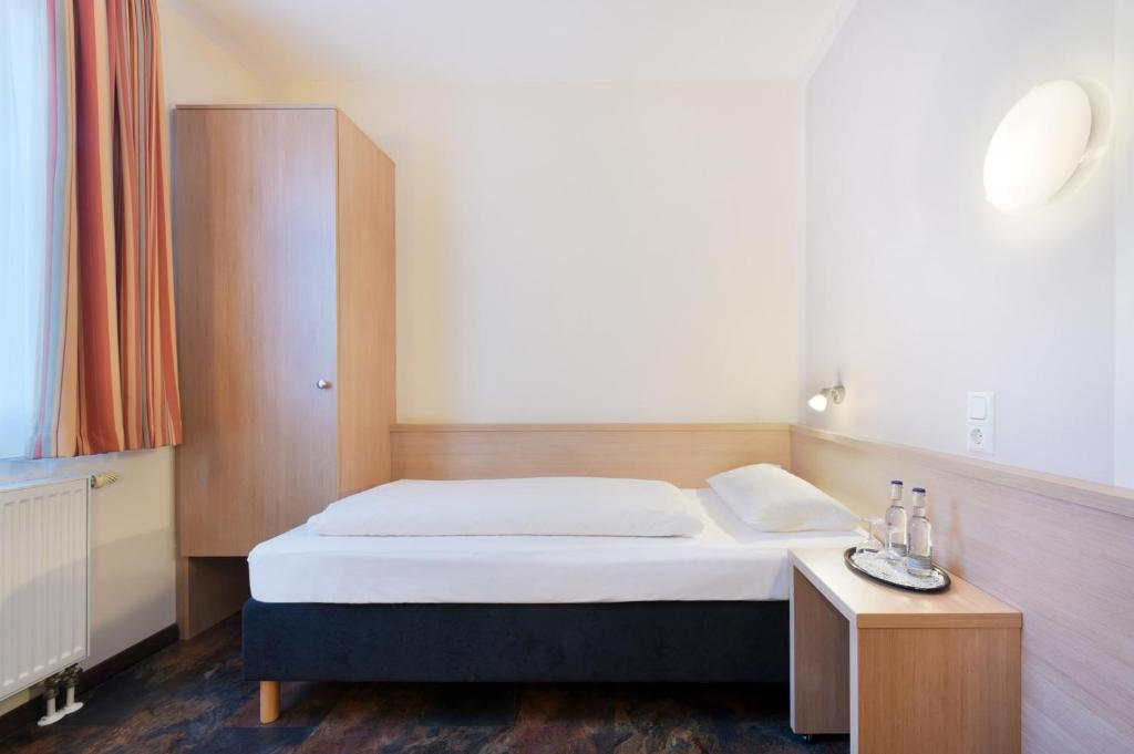a bedroom with a bed and a small table at meinHotel in Hamburg