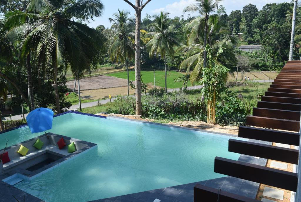 a swimming pool with stairs and palm trees at Muthu Nila villa- Mirissa in Mirissa