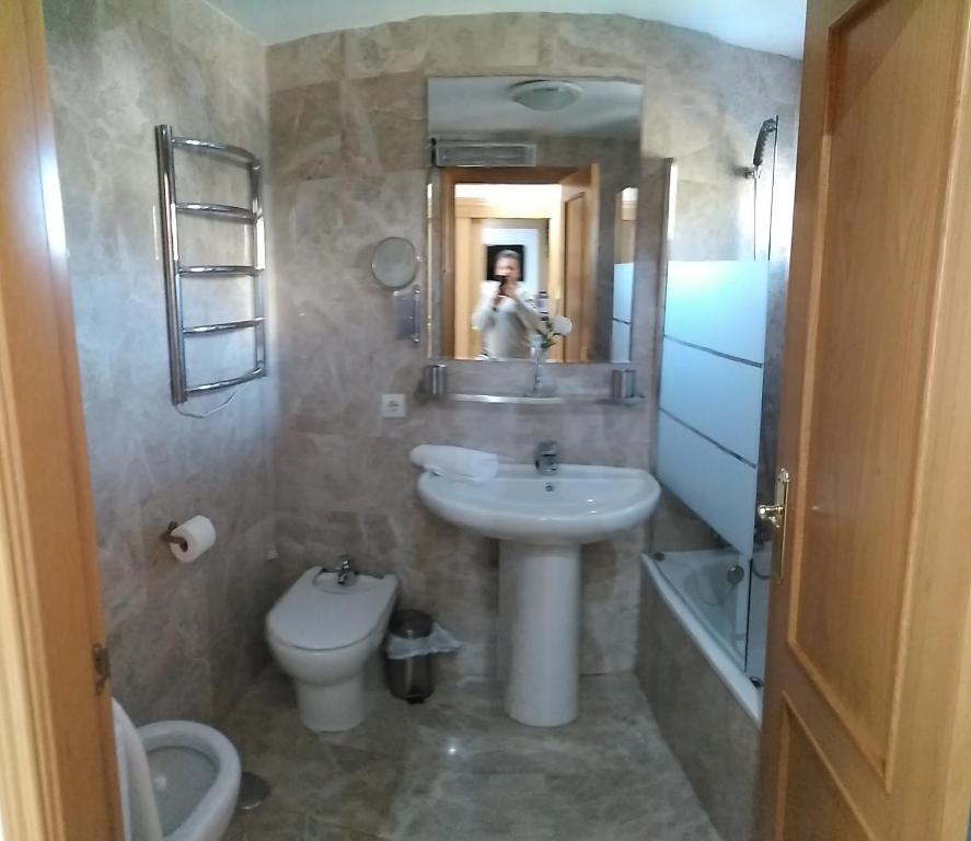 a bathroom with a sink and a toilet and a mirror at Snow in Miramar in Sierra Nevada