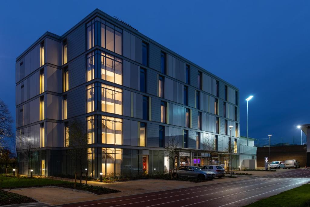 a large black building with cars parked in a parking lot at Elite Athlete Centre and Hotel in Loughborough