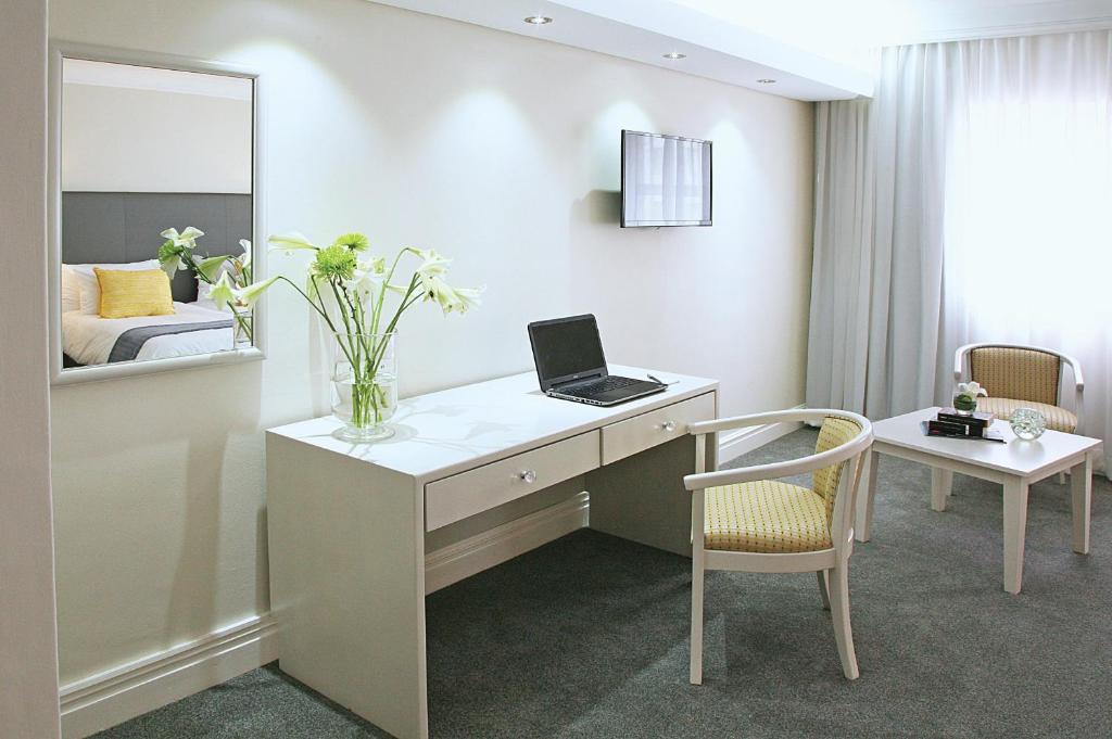 a room with a desk with a laptop and a mirror at Hollow on the Square City Hotel in Cape Town