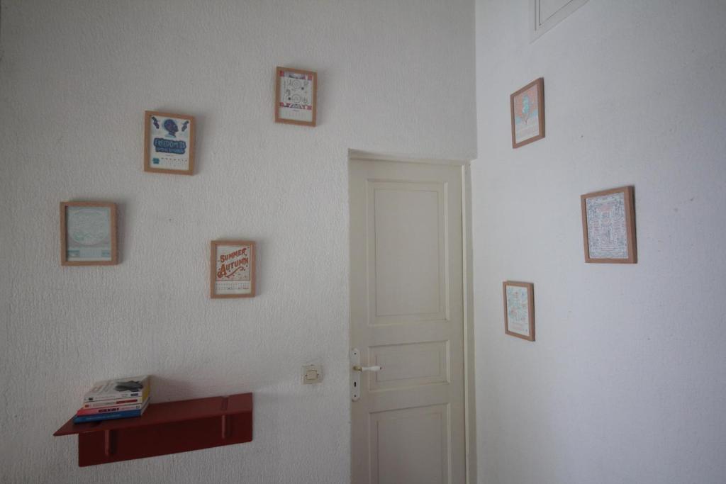 a room with a white wall with pictures on it at Villa Les Palmiers in Saint-François