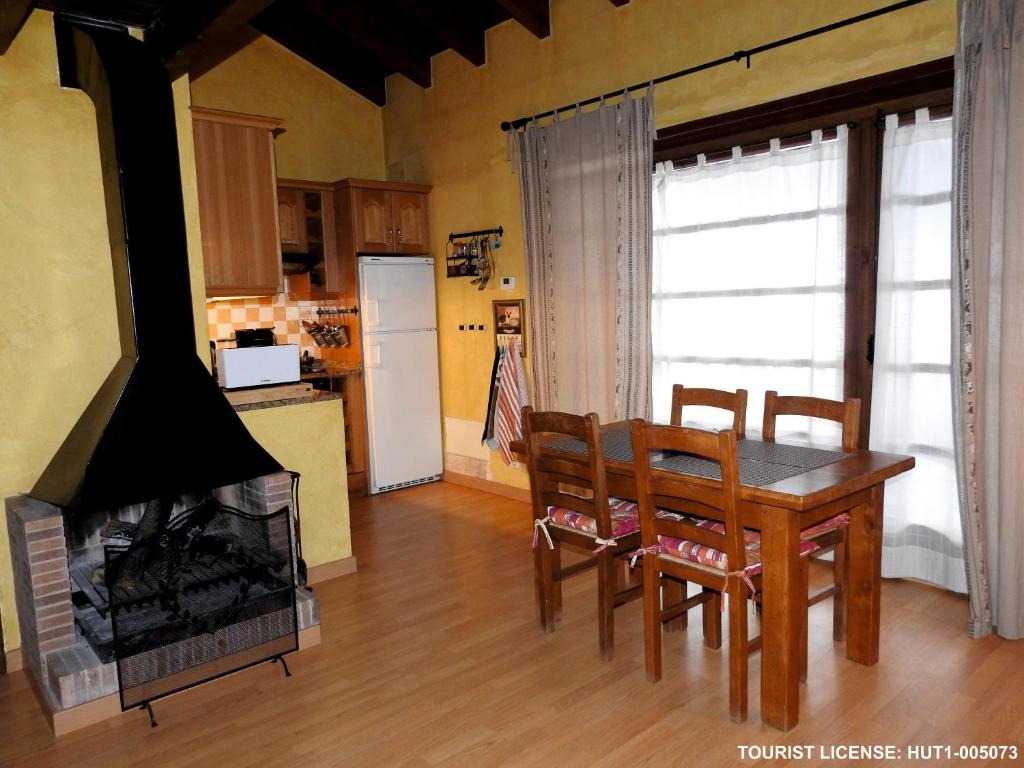 una cucina e una sala da pranzo con tavolo e camino di Acogedor Refugio en la Vall d'Incles a Incles