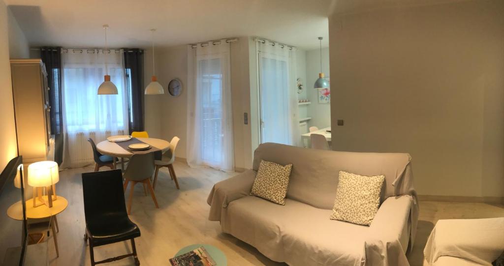 uma sala de estar com um sofá e uma mesa em Apartamento Turístico Puigcerdá Correos em Puigcerdà