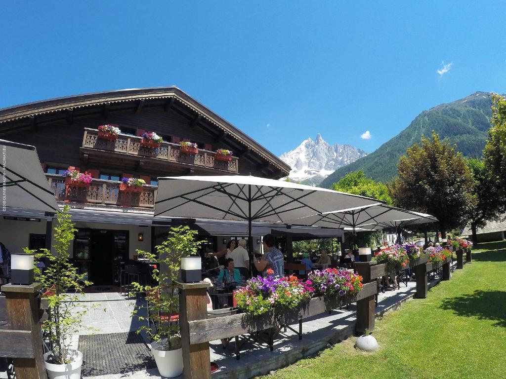 um restaurante com flores em frente a um edifício em Hotel Le Castel em Chamonix-Mont-Blanc