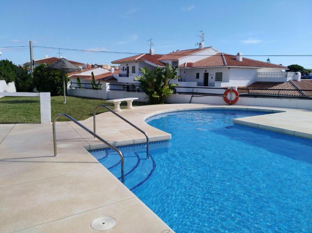 a swimming pool in front of a house at Apartamento El Faro de Mijas in Mijas Costa