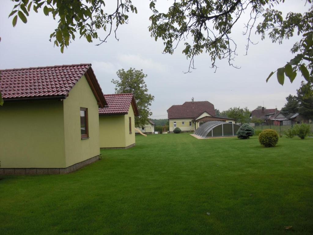 a yard of a house with a green lawn at Chatky v Českém ráji in Nemyčeves
