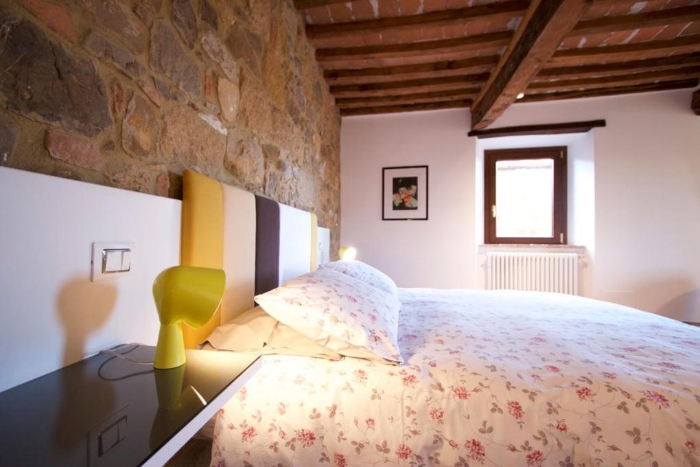 a bedroom with a large bed and a window at Torre appartamento con vista in Monticchiello