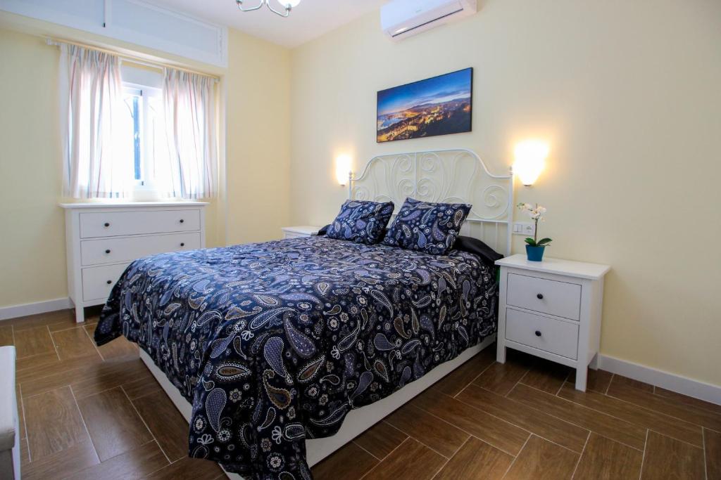 een slaapkamer met een bed en twee nachtkastjes bij Palacios 6, nuevo, playa, barrio tranquilo, todos los servicios, PA in Málaga