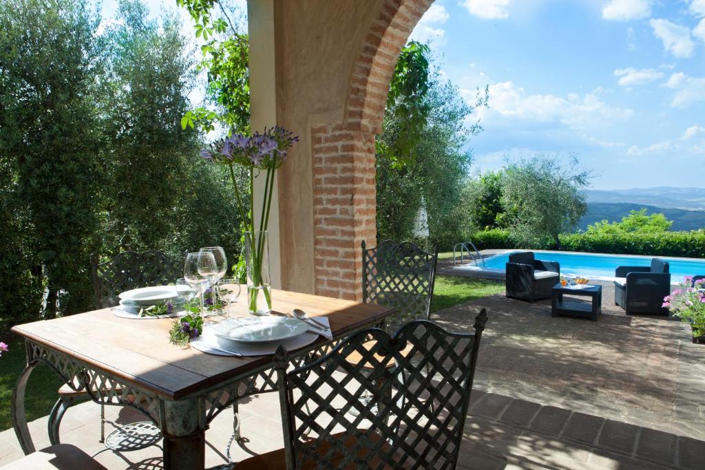 - une table et des chaises avec vue sur la piscine dans l'établissement Villa Fiorenzani, à Radicondoli