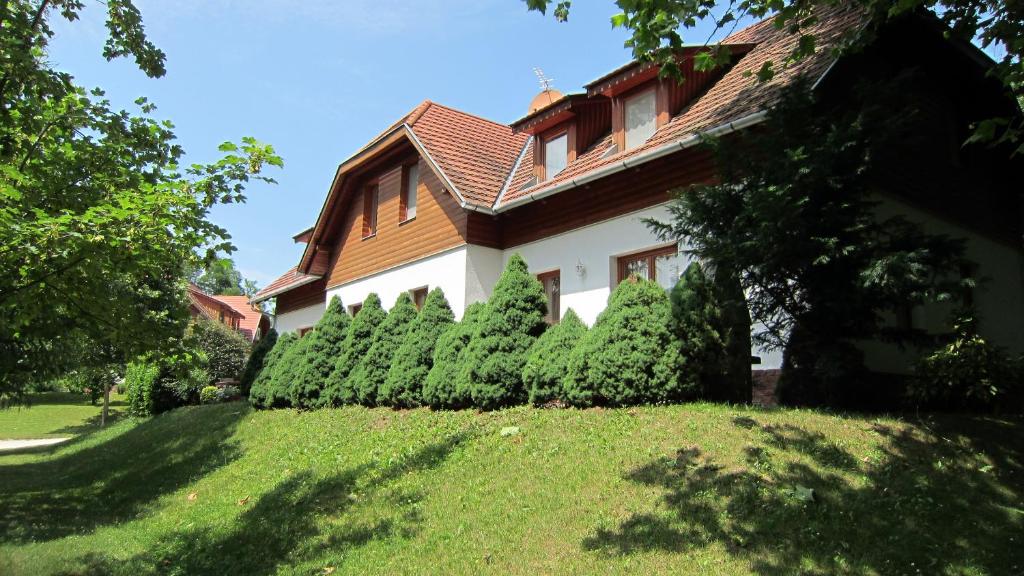 a house with a row of hedges in front of it at Appartement Kastelo Teraso in Zalacsány