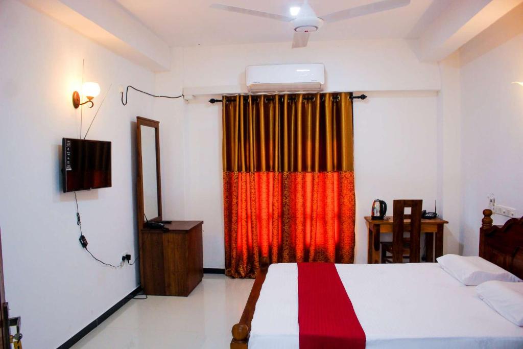 een slaapkamer met een bed en een rood gordijn bij Heritage Eco Resort Kelaniya in Kelaniya