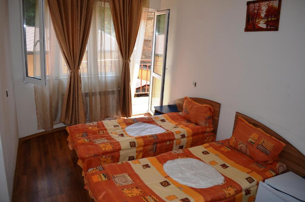 two beds sitting in a room with a window at хотел Европа in Shumen