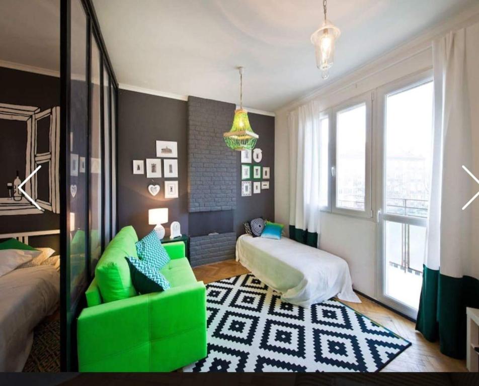 グダニスクにあるGrand-Tourist Apartments Green & Blueのリビングルーム(緑のソファ、ベッド付)