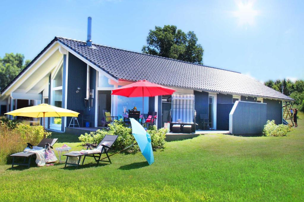 una casa con dos sombrillas en el patio en Ferienhaus Skagen, en Steinbergkirche