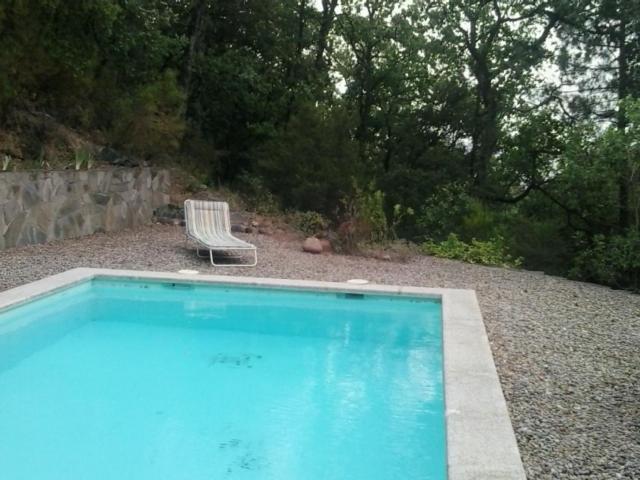 a swimming pool with a chair and a bench at Casa Montseny con piscina,bosque in Sant Pere de Vilamajor