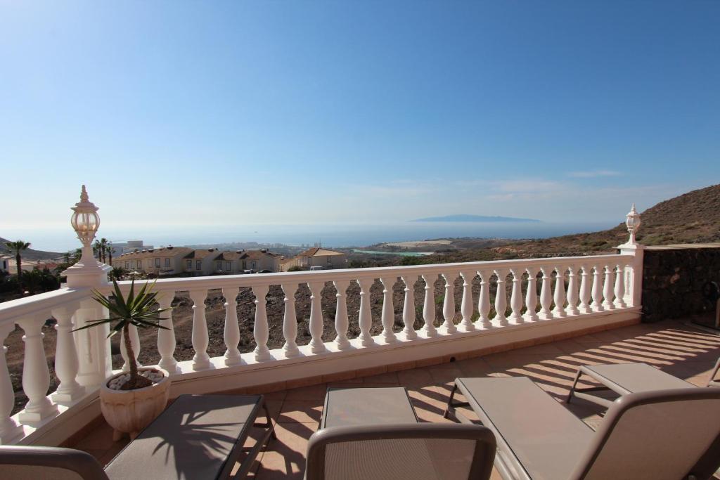 Un balcón con sillas y vistas al océano. en ViVaTenerife - Villa with pool, jacuzzi and sea view, en Chayofa