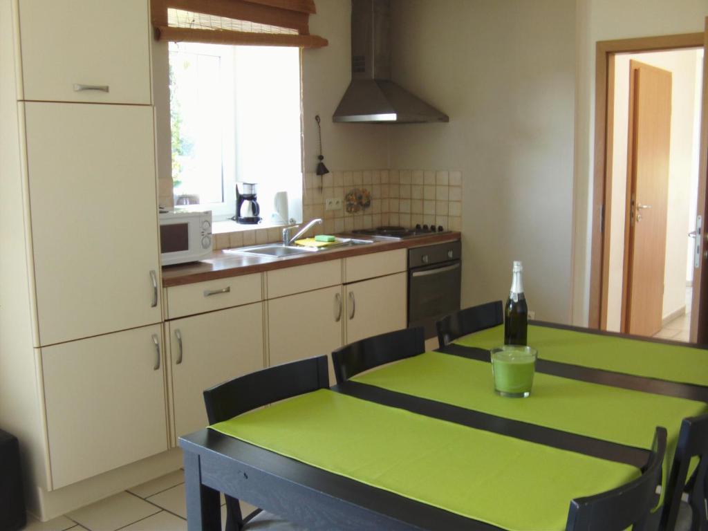 a kitchen with a table with a bottle of wine on it at Gîtes &quot;Les Framboisiers&quot; in Neufchâteau