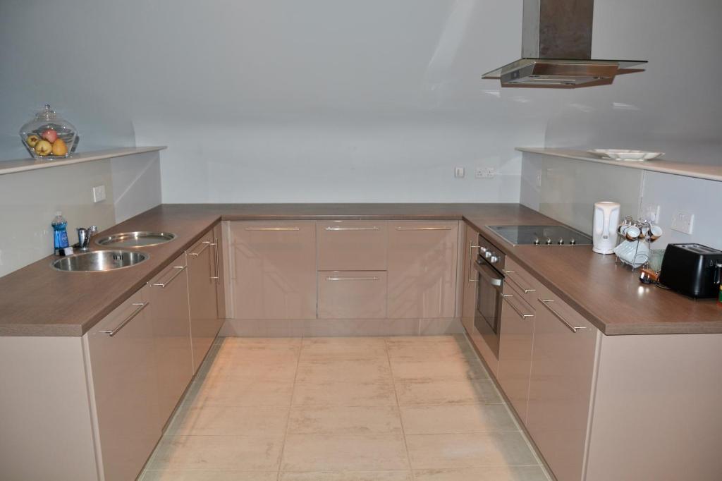 a kitchen with brown cabinets and a sink at Apartment 3, Oakleigh House, Donnybrook Hill, Douglas Cork in Cork