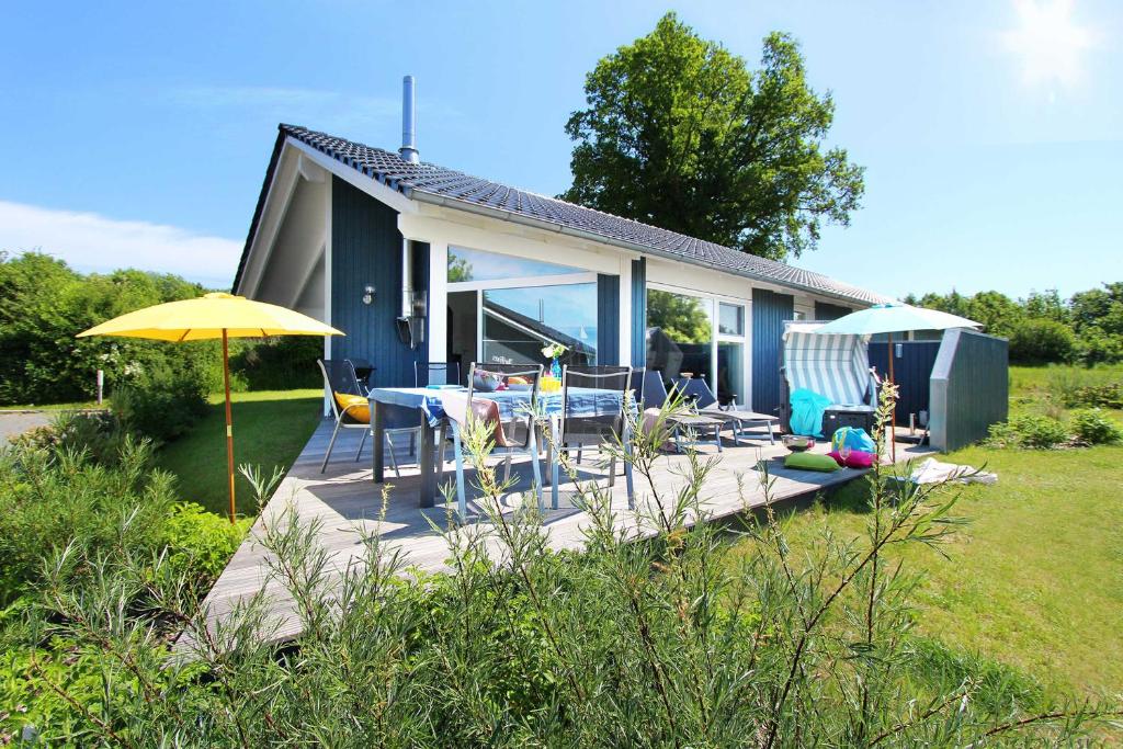 een huis met een terras met stoelen en een parasol bij Ferienhaus Randers in Steinbergkirche