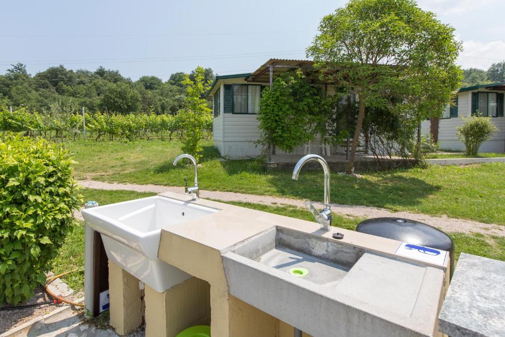 a concrete sink with two faucets on a yard at Kamp Romantik - glamping in Labin