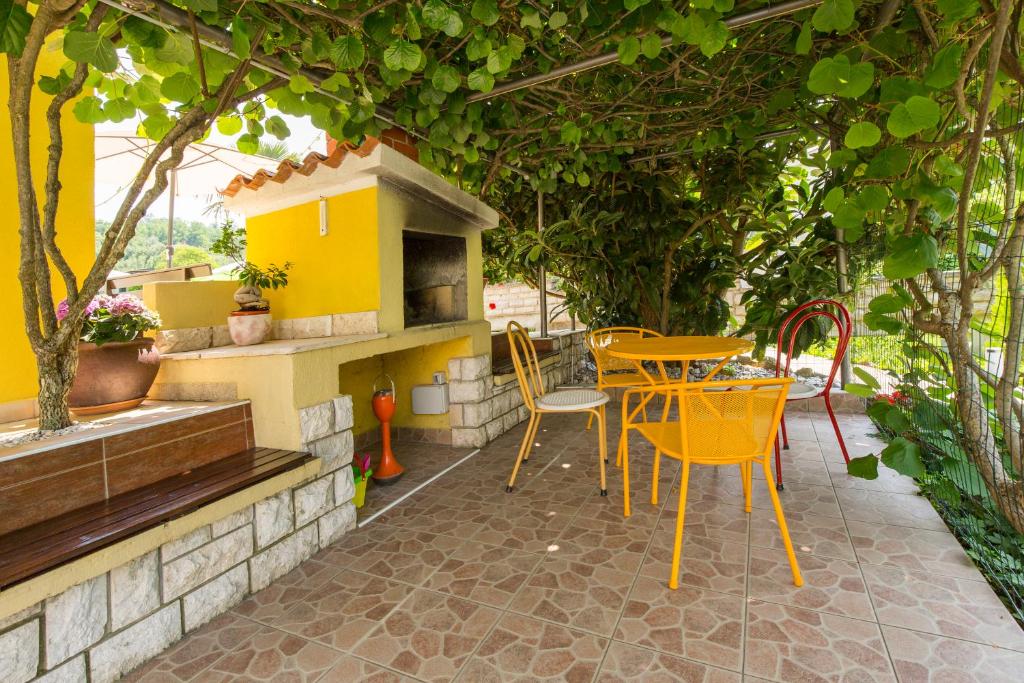 a patio with yellow chairs and a table with a stove at Kamp Romantik - glamping in Labin