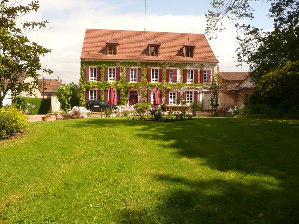 a large house with a large lawn in front of it at Chambres d'hôtes et Roulotte Au Bonheur Du Parc in Le Breuil