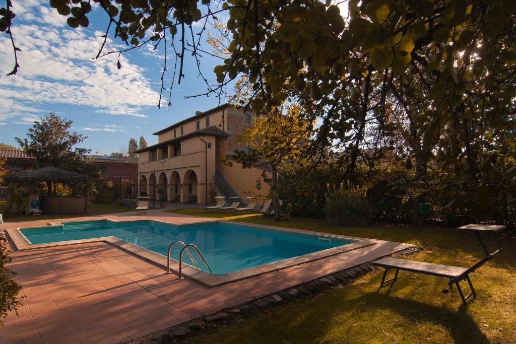 a swimming pool with a bench next to a house at Podere Violino in Sansepolcro