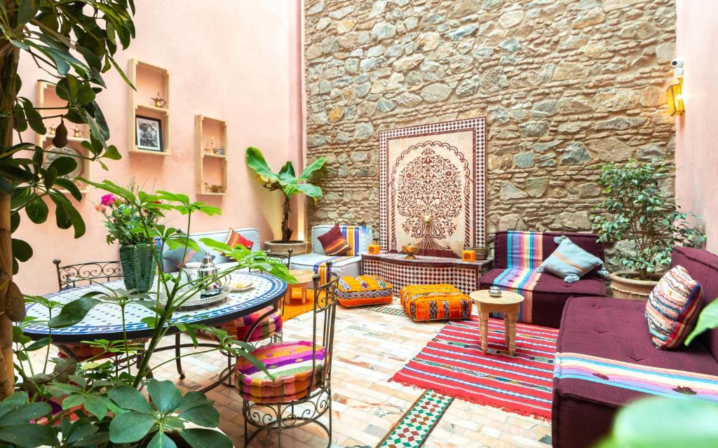 a patio with a table and chairs and plants at Riad Leila Marrakech in Marrakech