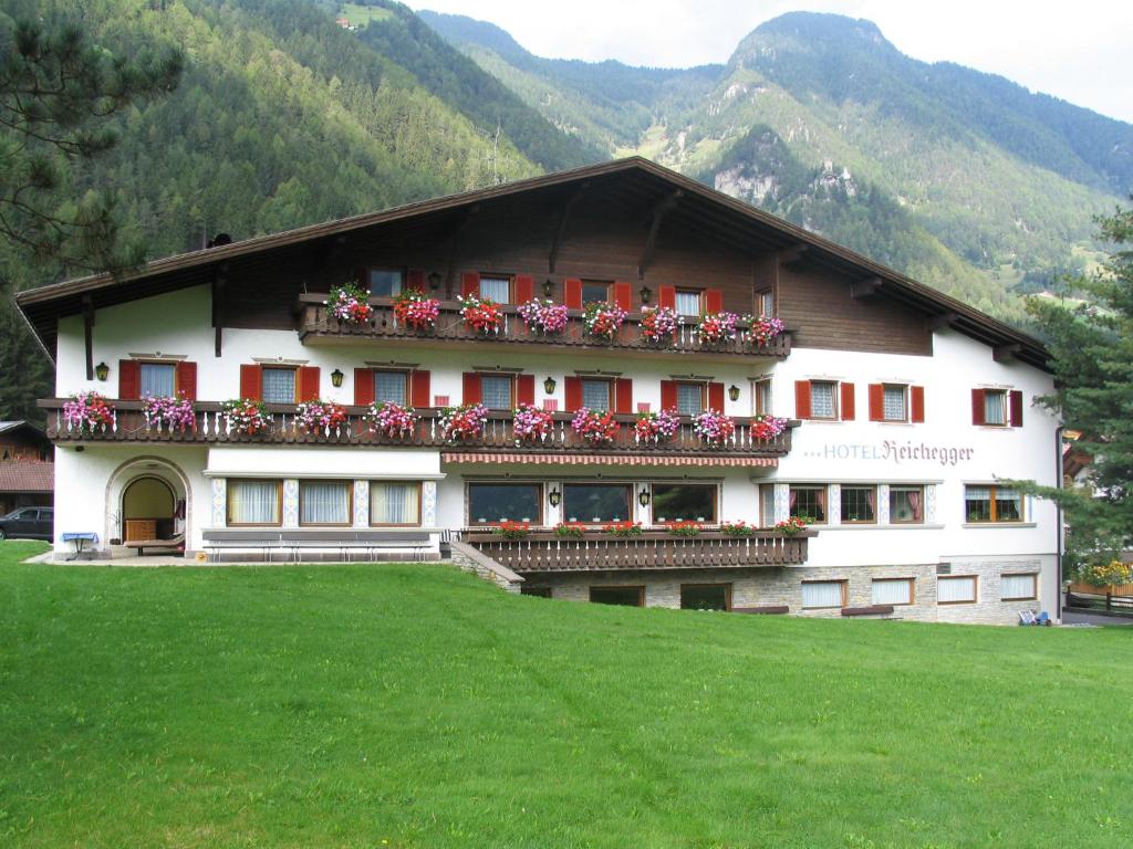 un bâtiment avec des fleurs sur ses balcons dans l'établissement Hotel Reichegger, à Villa Ottone