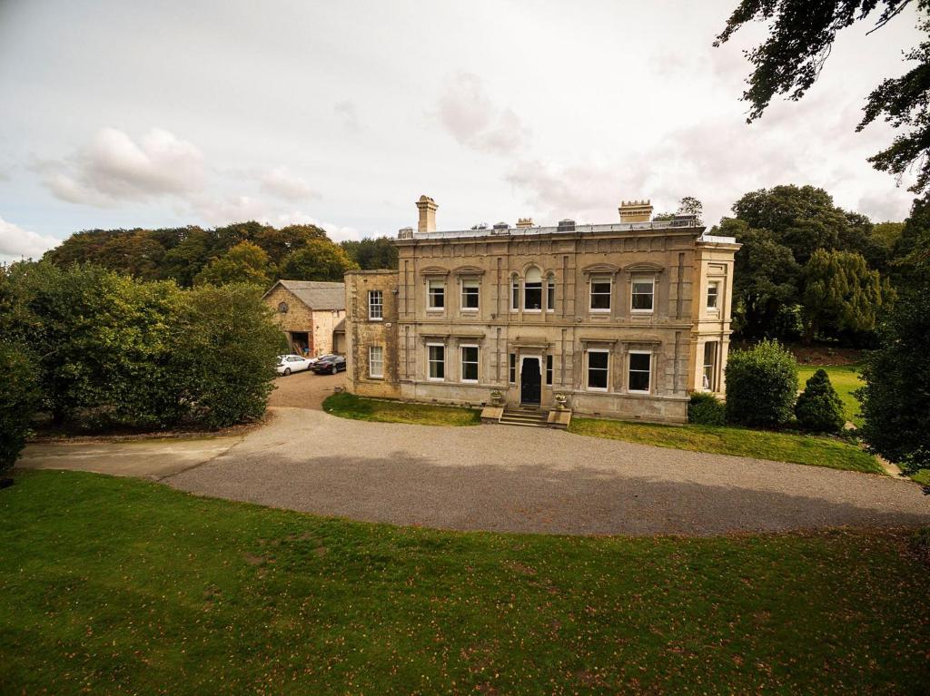 una antigua casa de piedra con una gran entrada en Cleatham Hall en Manton