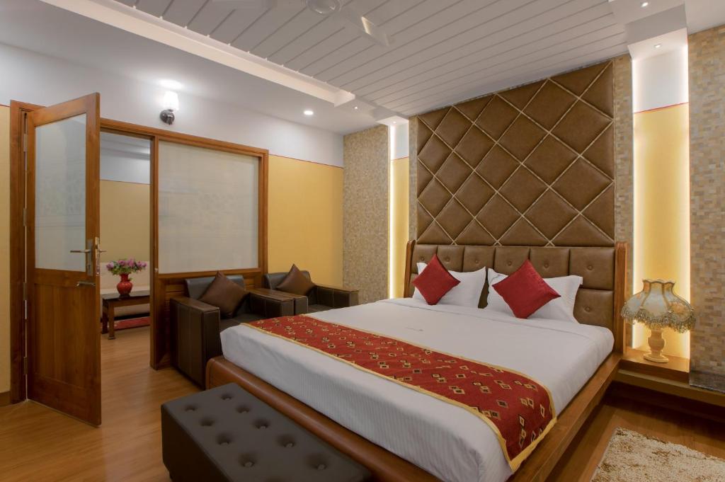 a bedroom with a large bed and a living room at Hotel Vashanth Krishna in Nāgercoil