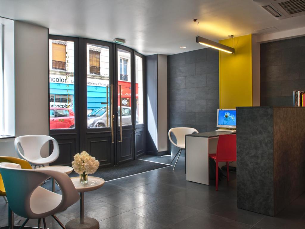 an office with a desk and chairs and a window at Hôtel des Métallos in Paris