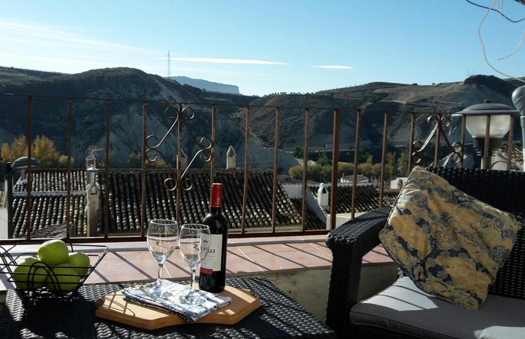 - une bouteille de vin assise sur une table avec des verres à vin dans l'établissement Casa De Juanita Vivienda Rural, à Hinojares